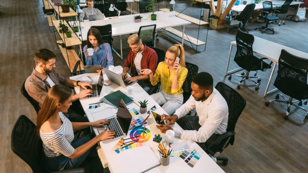 Processus de travail. Équipe de designers travaillant dans un espace de coworking, vue en plongée.