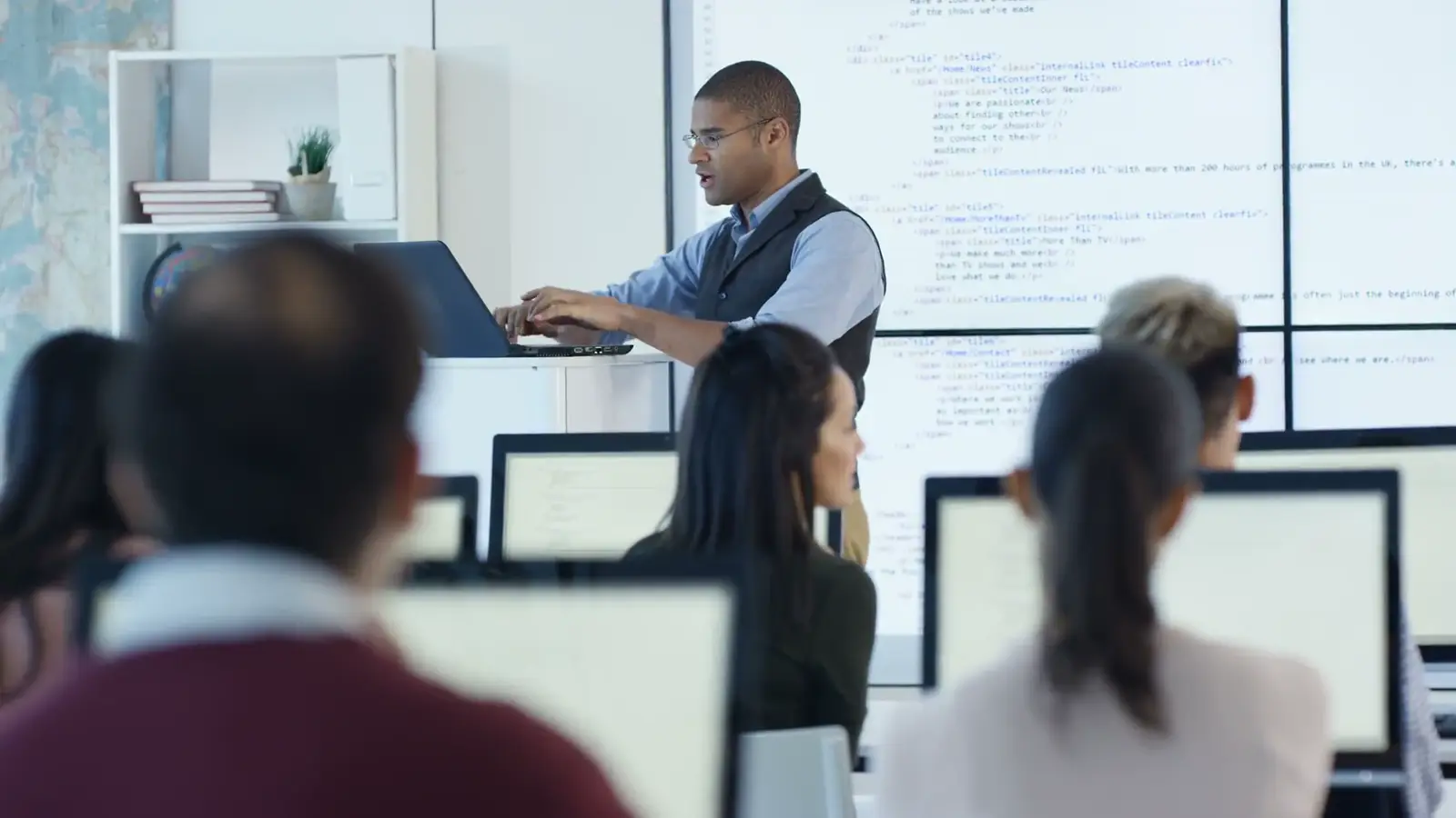 Formateur devant une salle d'apprenants sur ordinateur